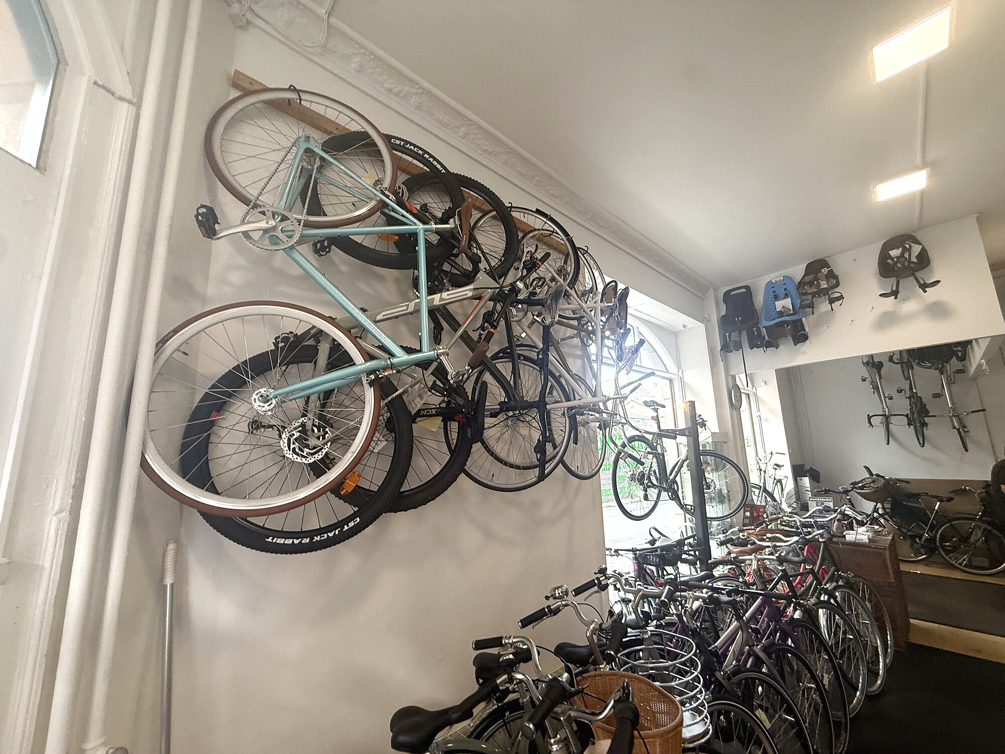 Bikes hanging on the wall inside Le Tour Cykler in Nørrebro